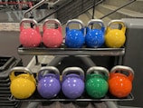 Close-up of colorful kettlebells lined up on the gym floor ready for use