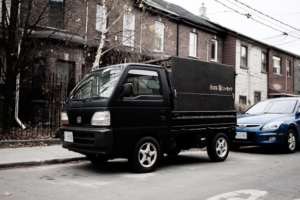 A compact mini truck from darttruck service navigating a busy city street.