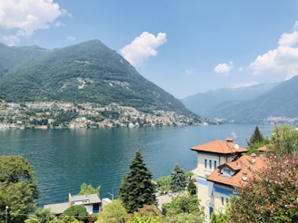 white and brown concrete house near body of water during daytime