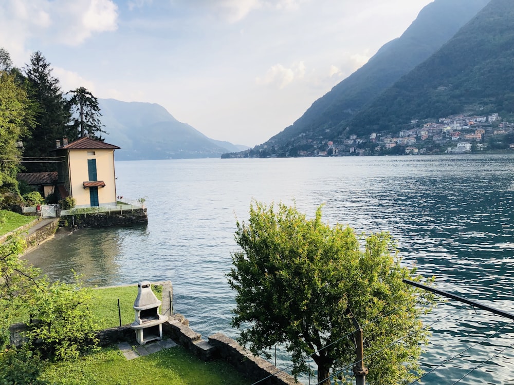 white and brown wooden house near body of water during daytime