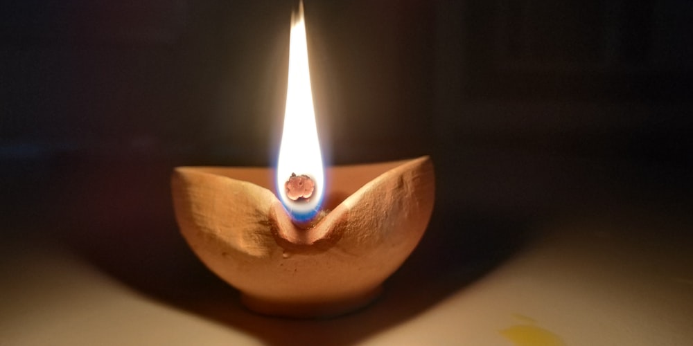 lighted candle in brown wooden holder