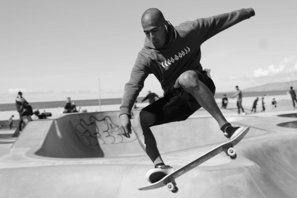 man in black and white long sleeve shirt and blue denim jeans riding skateboard