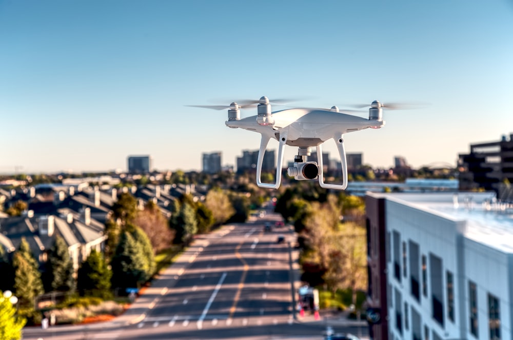 white drone flying over the city during daytime