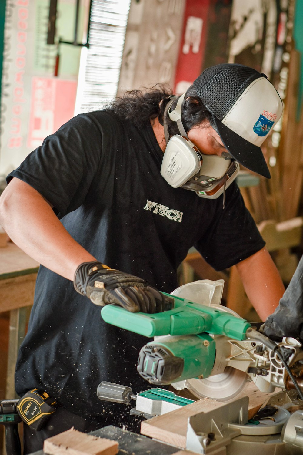 man in black crew neck t-shirt holding green and gray power tool