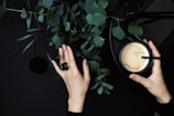 A hand wearing a stylish black ring while holding a coffee cup.