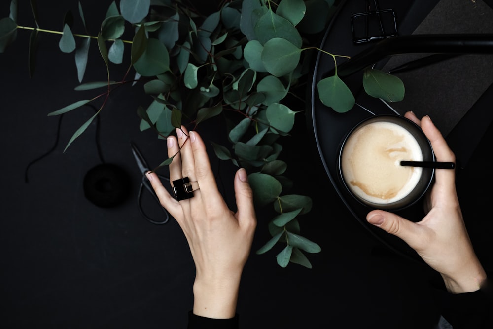 person wearing silver ring holding green plant
