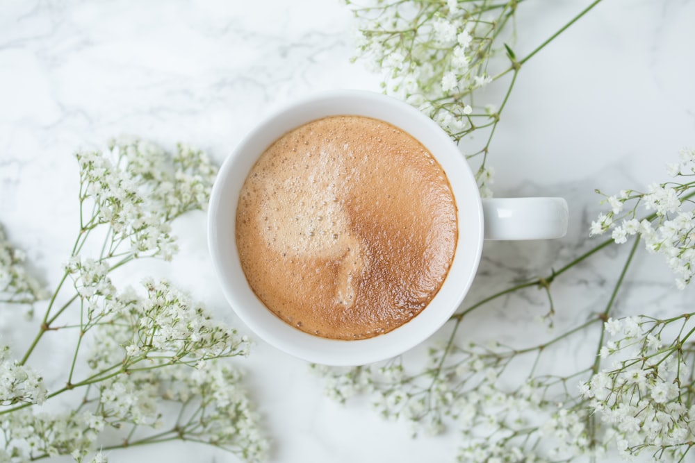 white ceramic mug with brown liquid