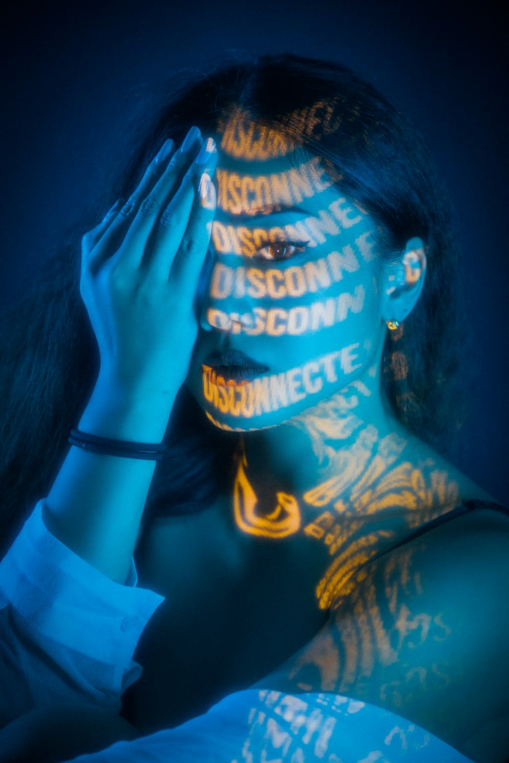 Femme en débardeur noir avec tatouage bleu et jaune sur sa main gauche