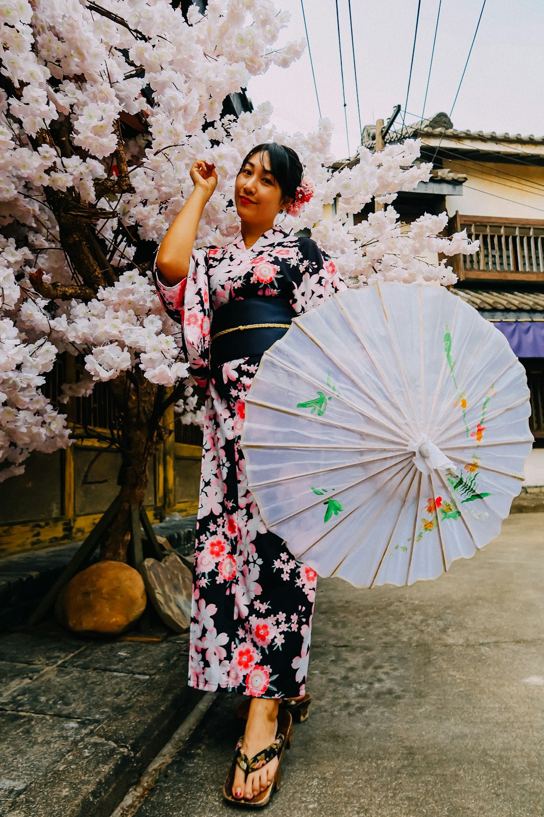 woman in black and pink floral kimono holding umbrella