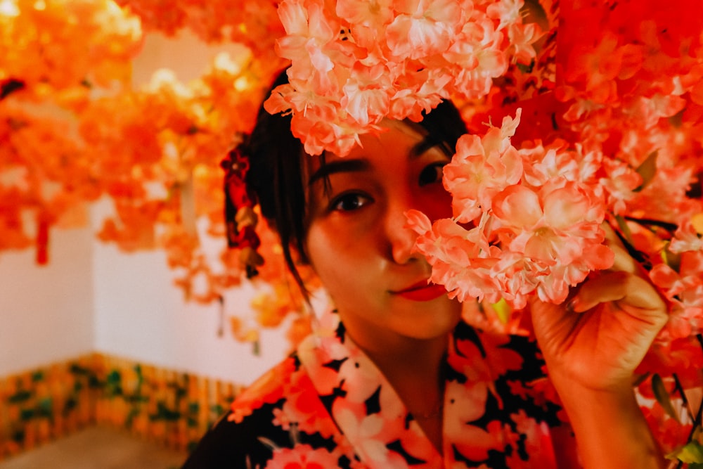 woman in black and red floral shirt with white and pink flower on her head