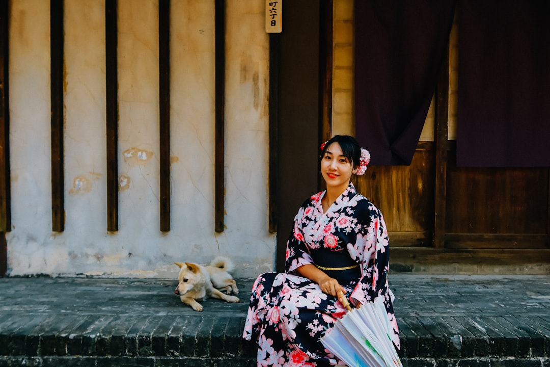 woman in black white and pink floral dress sitting on concrete stairs