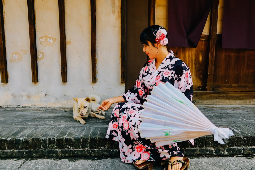 woman in black and red floral kimono sitting on concrete stairs