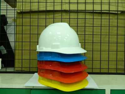 Bright yellow safety helmets stacked beside a toolbox on a construction site.