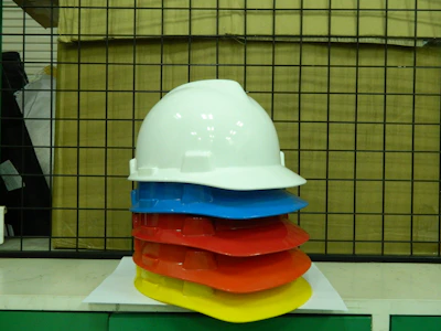 Colorful construction helmets lined up on a bright yellow background
