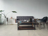 A minimalist living room featuring a nordlys side table with a small plant and a book.