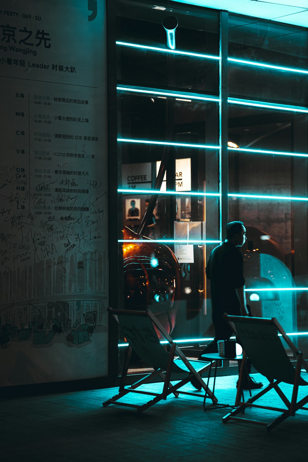 man in black shirt standing near glass window