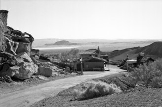 Photograph of a rugged western landscape with a government building in the distance.