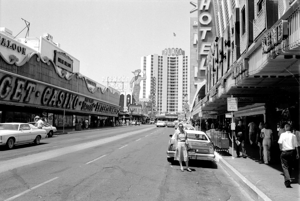 grayscale photo of cars on road near buildings