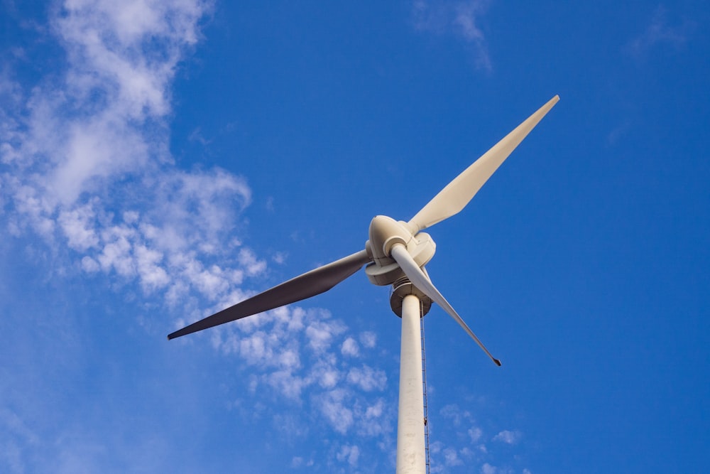 white wind turbine under blue sky during daytime