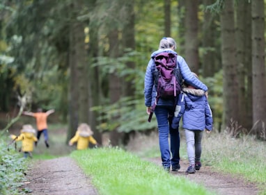 woman in blue denim jeans and black jacket walking with woman in green jacket