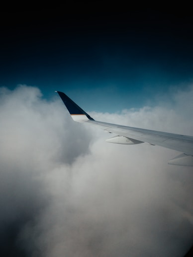 white and blue airplane wing under blue sky during daytime