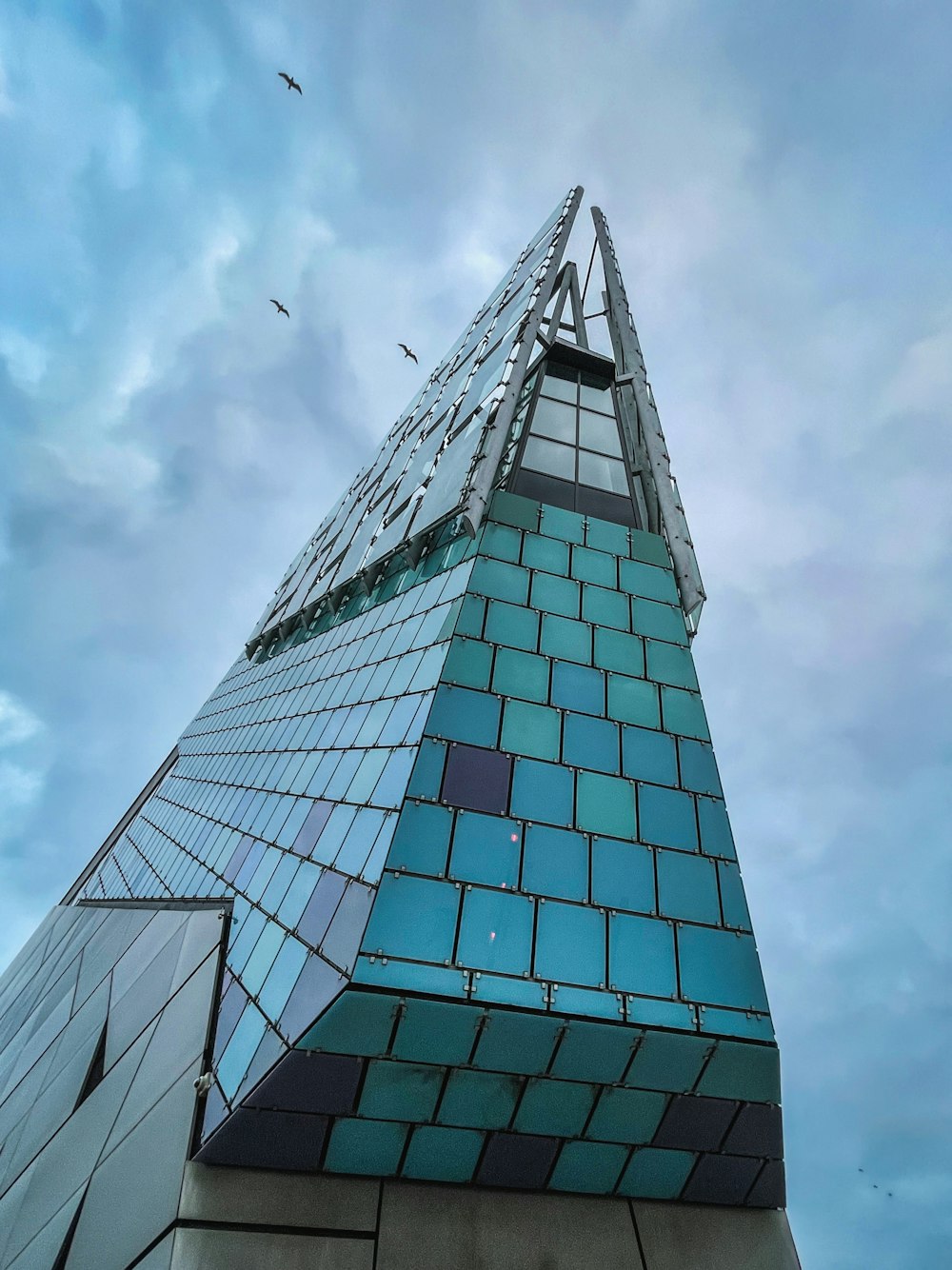 fotografia ad angolo basso dell'edificio di vetro sotto il cielo blu durante il giorno