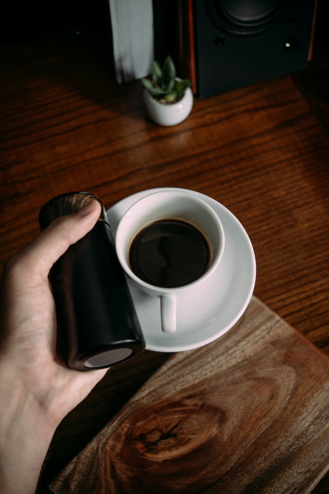 person holding white ceramic mug with black liquid