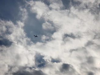 Silhouetted aircraft flying high above the horizon, preparing for the next jump with parachutes visible inside.