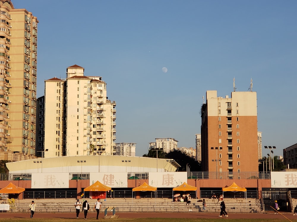 people walking on park near high rise buildings during daytime