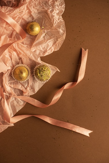 A beautifully arranged gift basket with pastel pink and green ribbons, filled with gourmet sweets and elegant packaging.