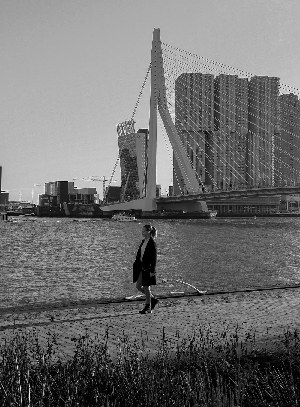 man in black jacket and pants holding fishing rod standing on dock during daytime