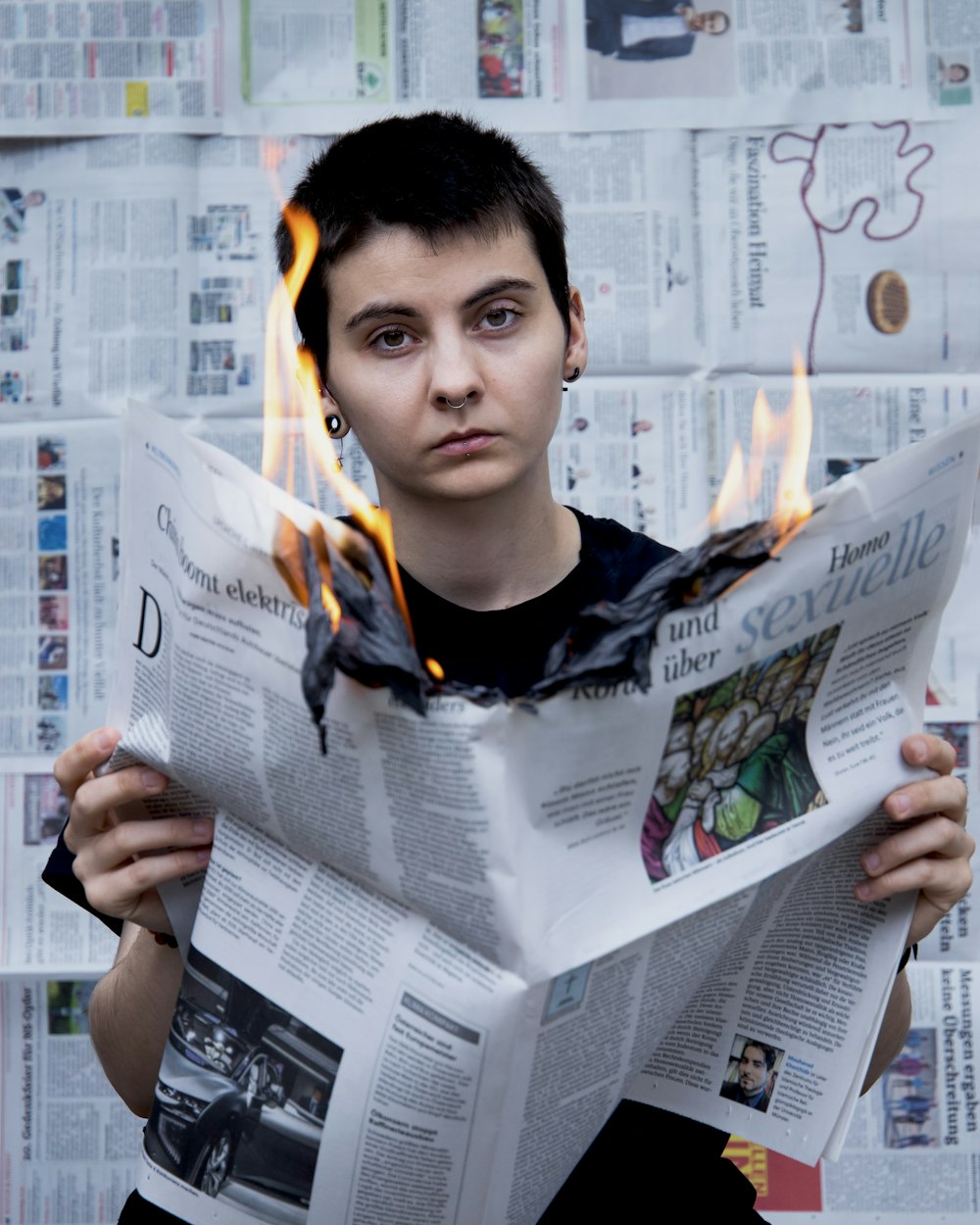 man in black crew neck shirt holding newspaper