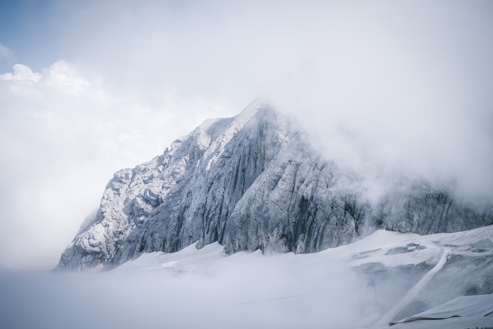 snow covered mountain under cloudy sky during daytime