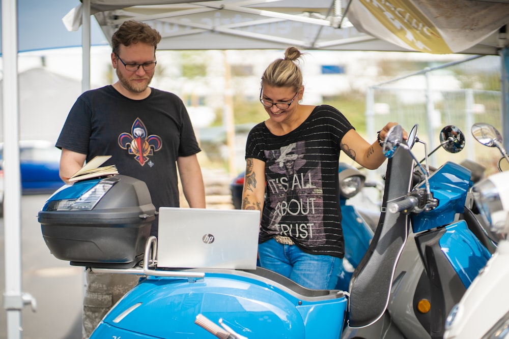 man in black crew neck shirt sitting on blue and silver motorcycle