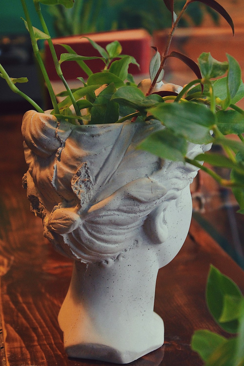 white ceramic flower vase with green leaves