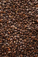 brown coffee beans on black surface