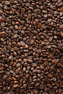 brown coffee beans on black surface