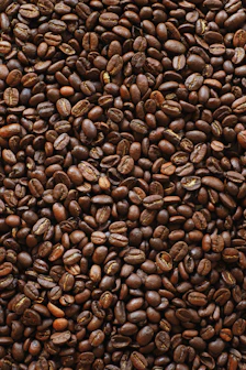brown coffee beans on black surface