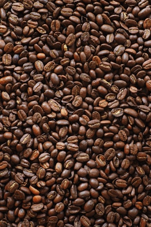 brown coffee beans on black surface