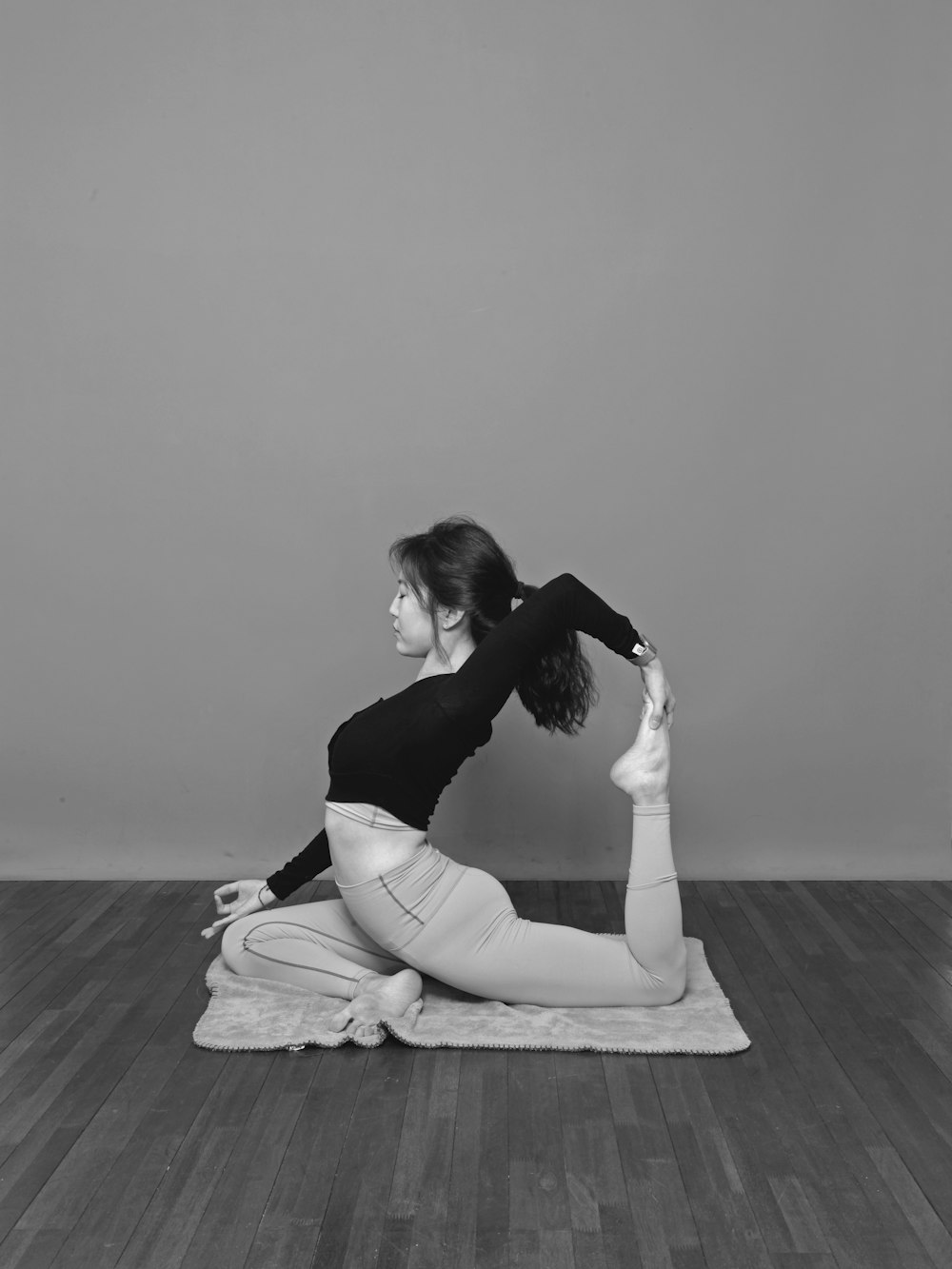 woman in black tank top and white pants sitting on floor