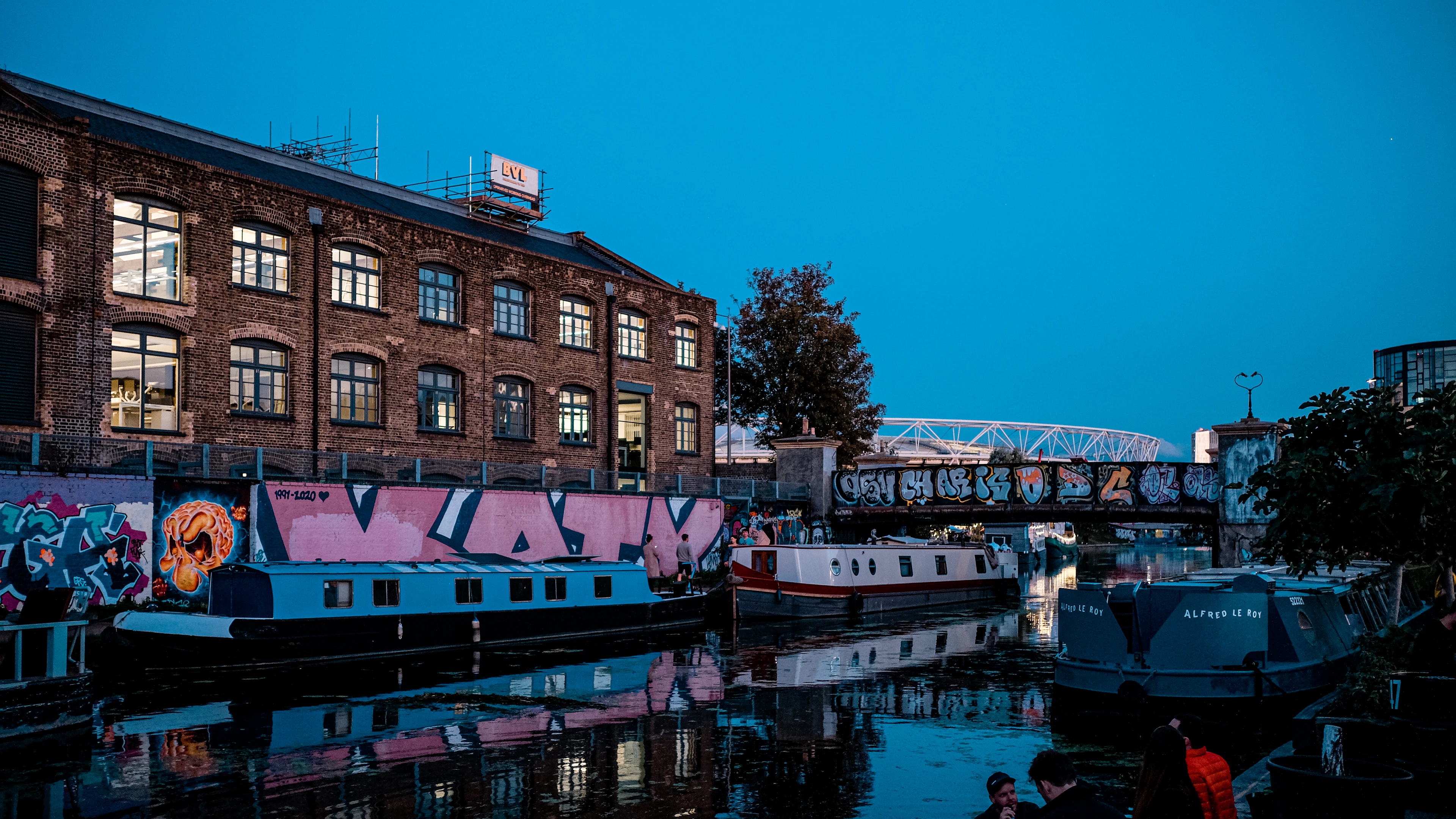 Graffiti-covered warehouses and narrowboats on the canal at Hackney Wick