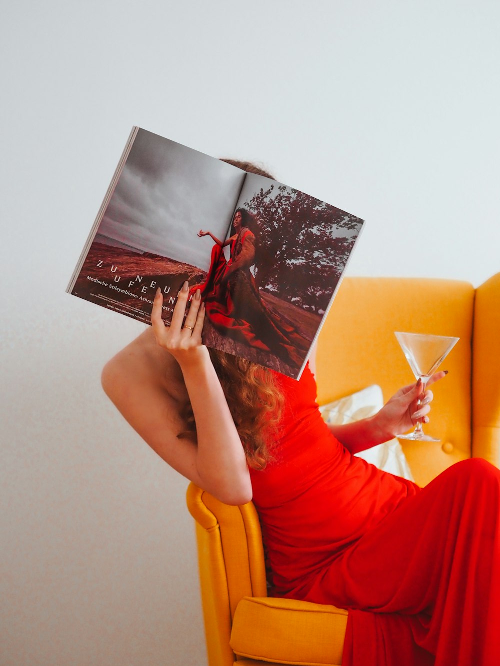 woman in red dress sitting on yellow sofa chair