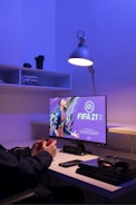A dynamic EA Sports FC 26 creator streaming gameplay with branded gear in a sleek studio.