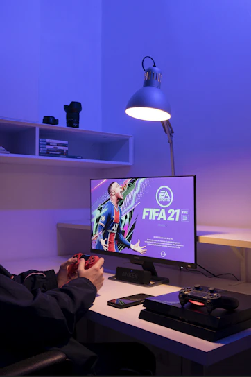 A cozy gaming setup featuring a PlayStation 5 console with a vibrant digital game displayed on the TV screen.