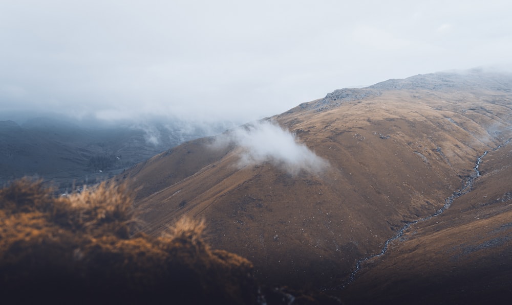 brown mountain under white clouds during daytime