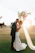 A romantic candid shot of a bride and groom sharing a joyful moment bathed in soft golden light.