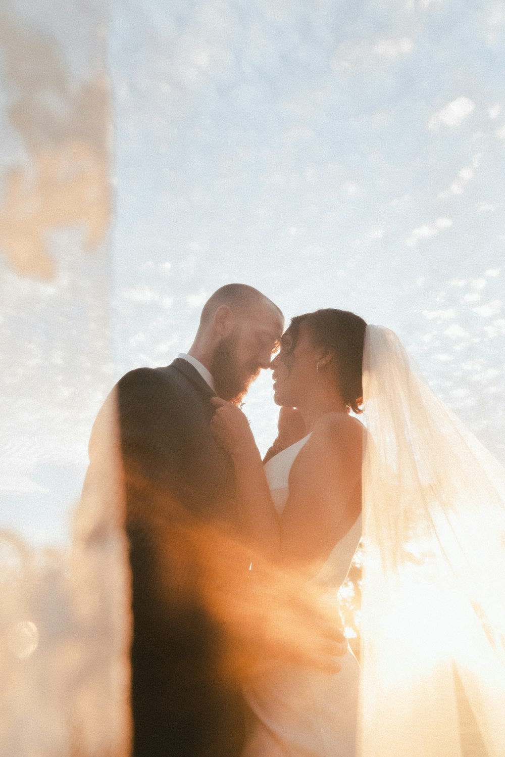 man and woman kissing under blue sky during daytime