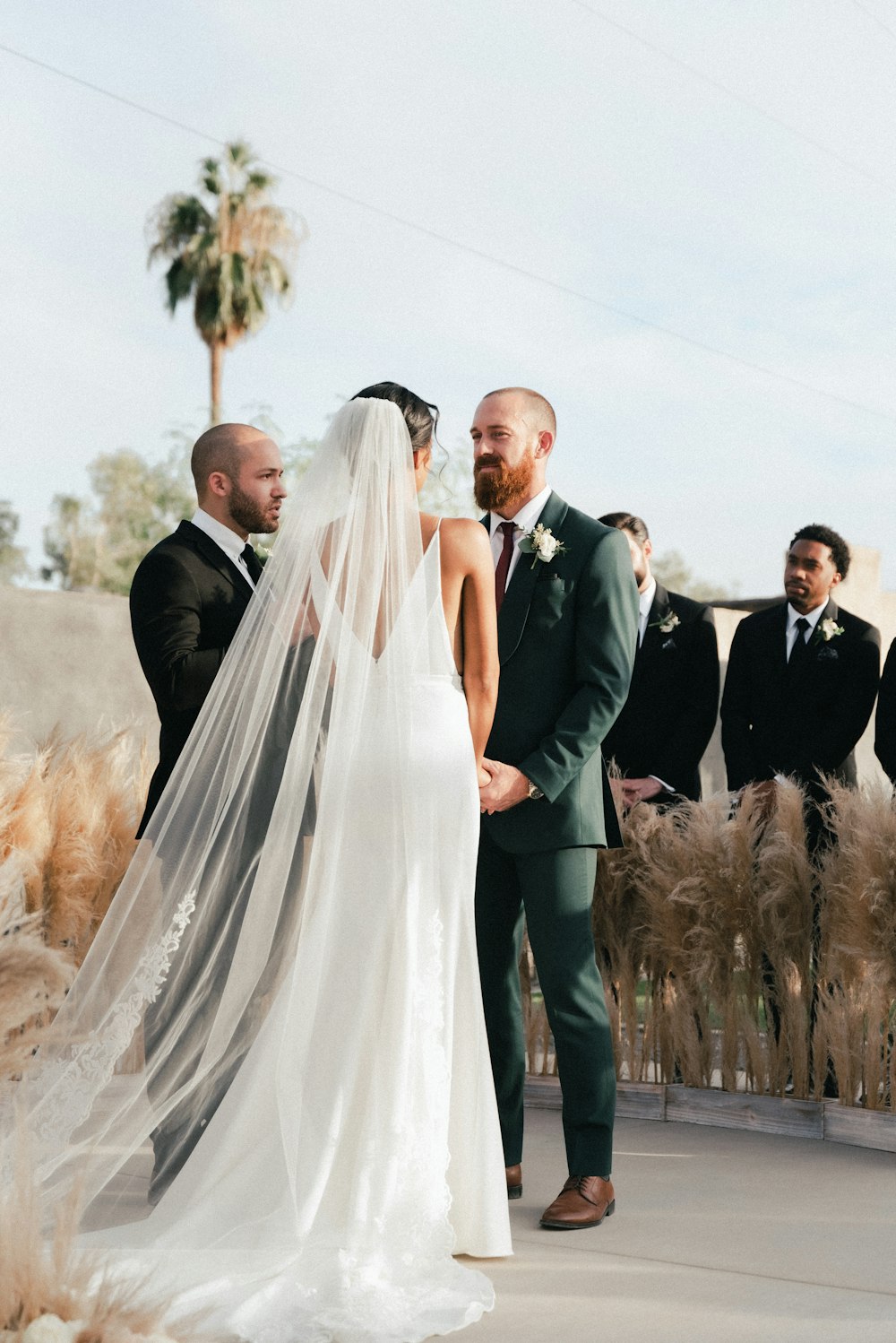 bride and groom standing on grass field during daytime