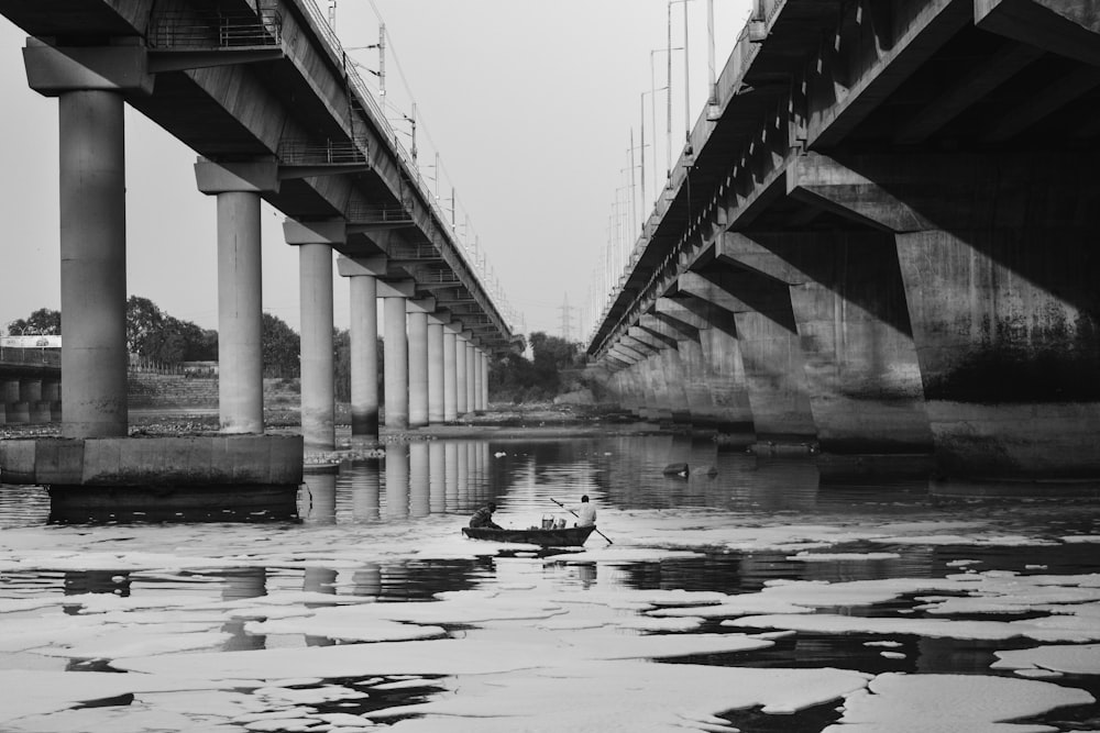 Photo en niveaux de gris d’un pont au-dessus de l’eau