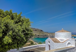A serene coastal site with a geodesic dome structure nestled amidst rugged maritime landscape under a soft morning sky